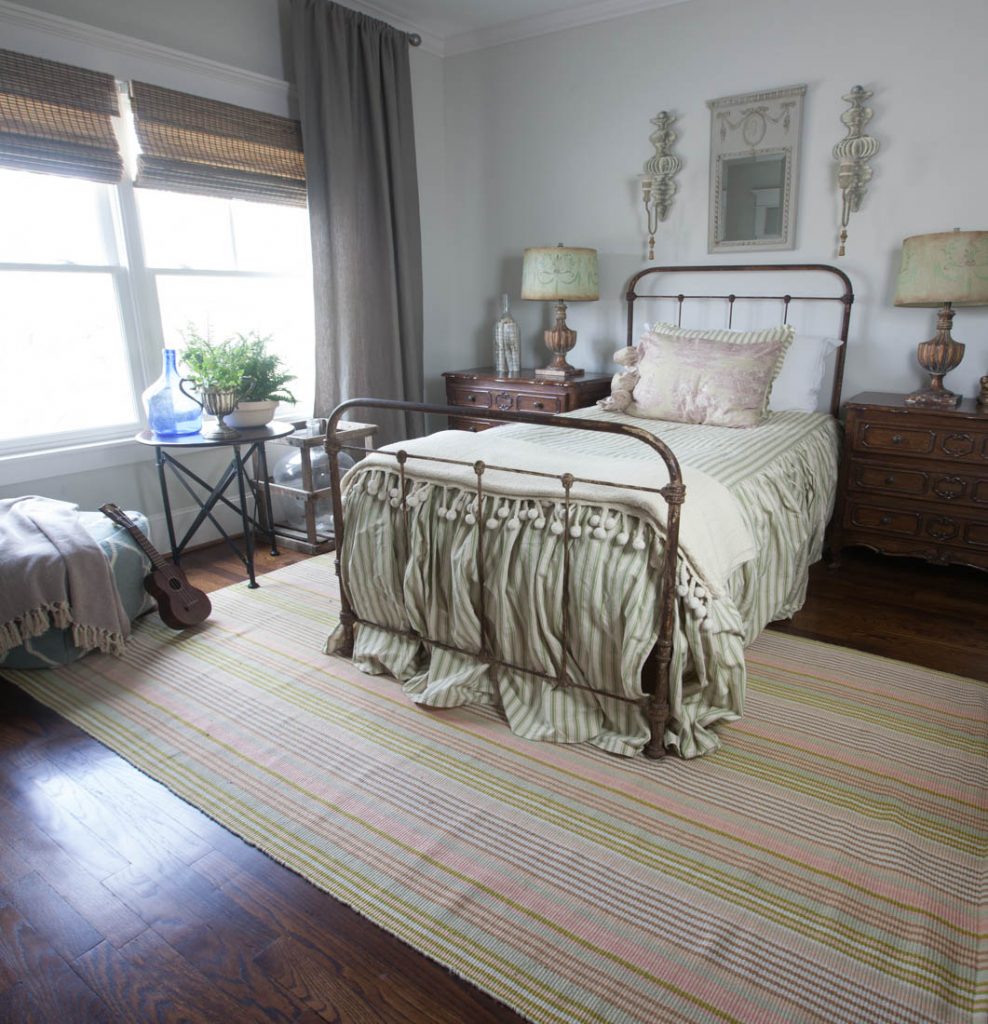 striped rug and green bed