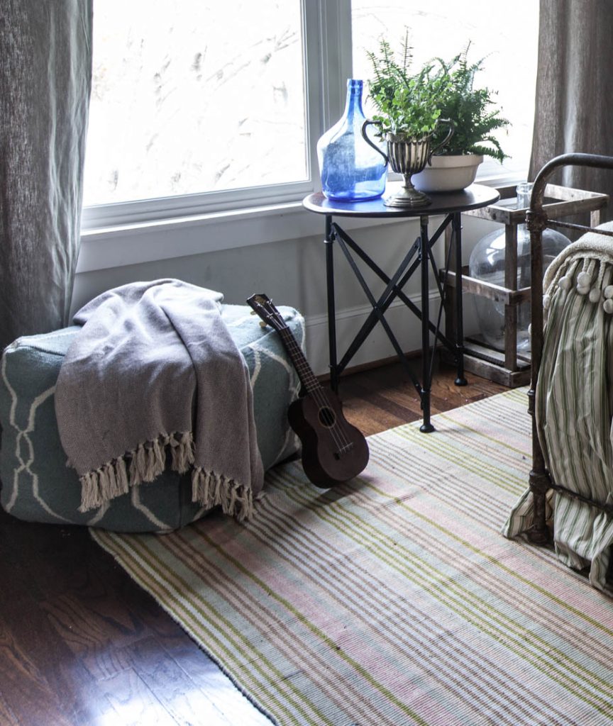 striped rug and green bed and window