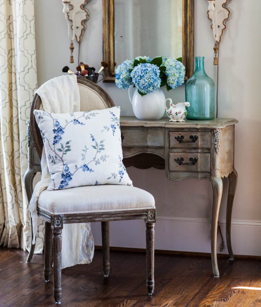 blue floral embroidery pillow on chair