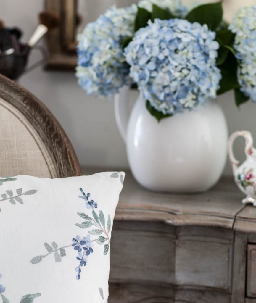blue floral embroidery pillow and hydrangeas